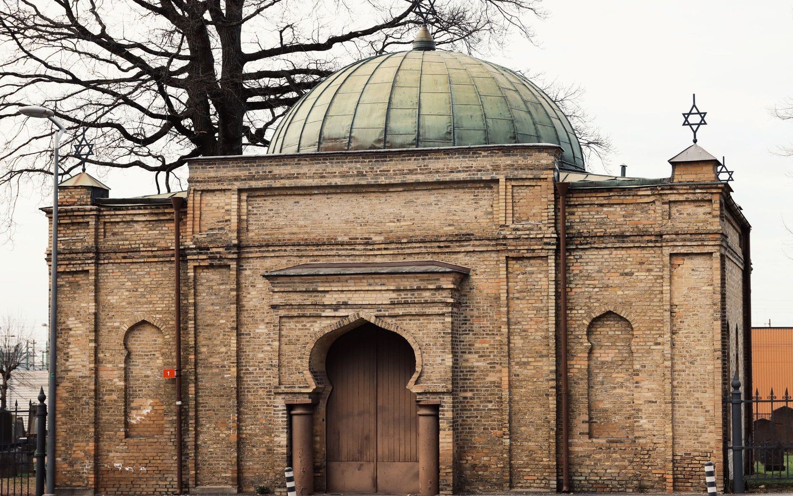 Brick mortuary building with a green domed roof and Star of David finials