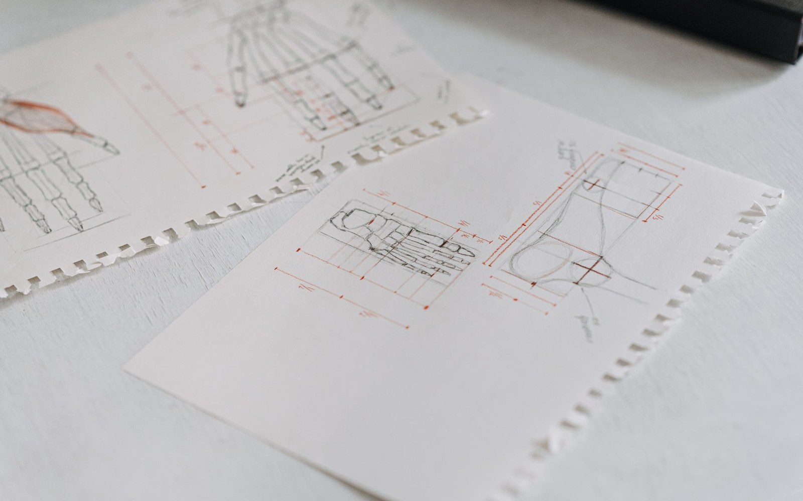 A reproduction of a 1920s measured elevation drawing of the Zabłudów synagogue, shown as a physical sheet of paper on a drawing table