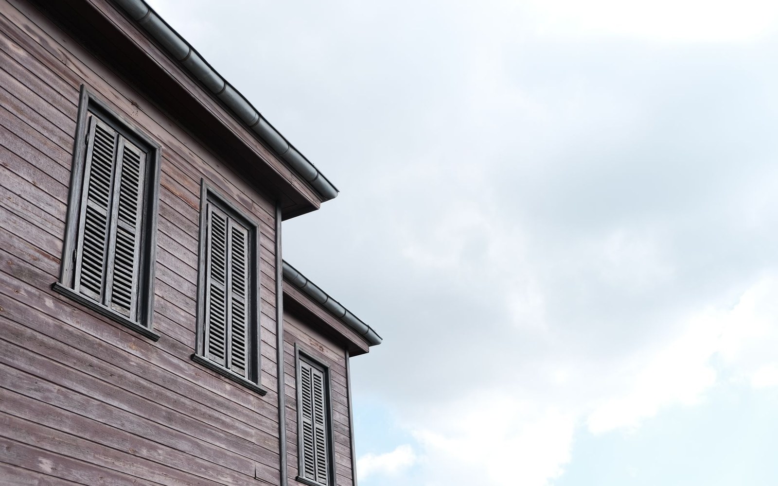 A wooden shingle roof seen from directly beneath the eave, courses of split shingle visible in perspective, a Podlaskie building